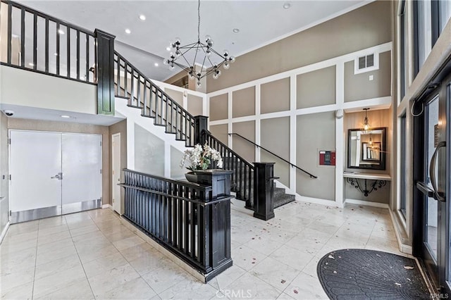 stairway featuring a notable chandelier and a towering ceiling