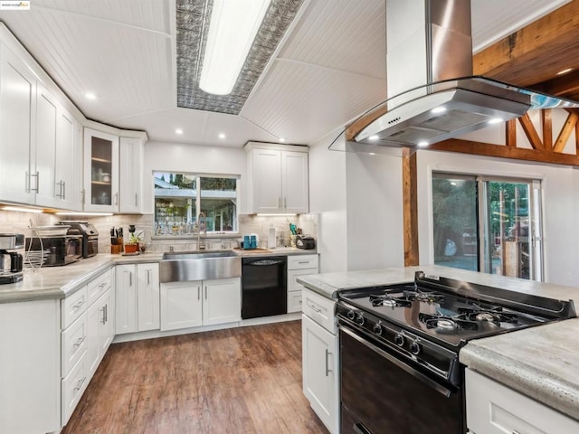 kitchen featuring white cabinetry, light hardwood / wood-style floors, range hood, black appliances, and sink