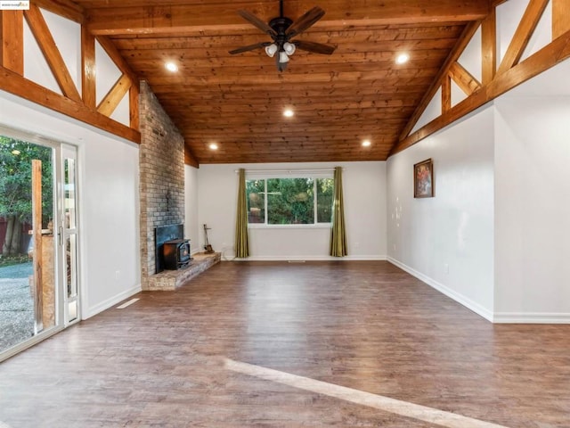 unfurnished living room featuring hardwood / wood-style flooring, a wood stove, high vaulted ceiling, and beamed ceiling