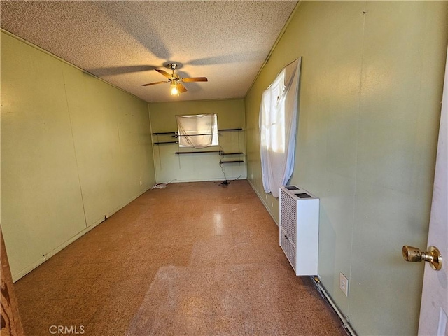 interior space featuring heating unit, a textured ceiling, and ceiling fan