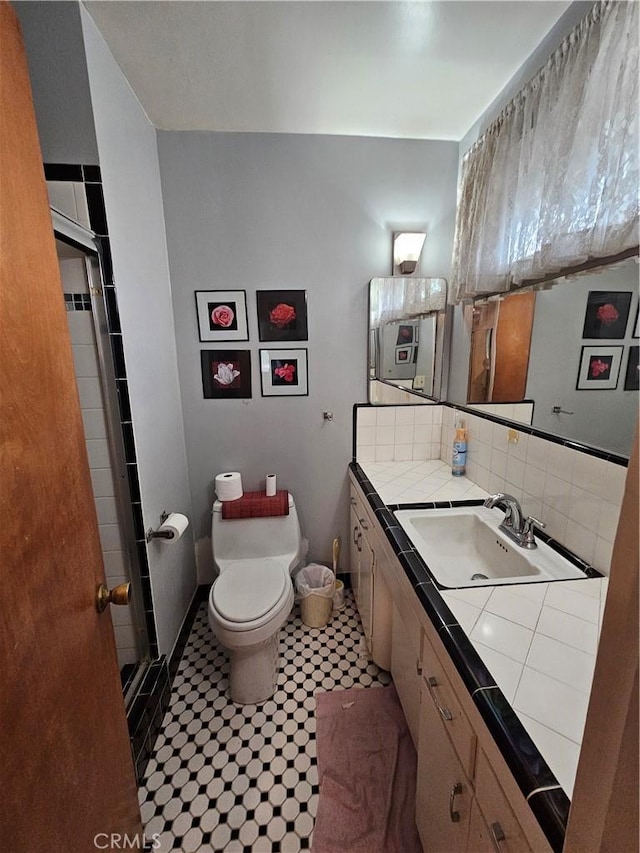 bathroom with vanity, backsplash, and toilet