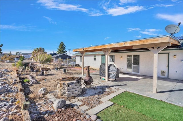 rear view of house with an outdoor fire pit and a patio area