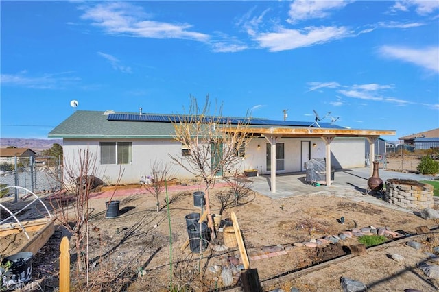 back of property featuring solar panels and a patio