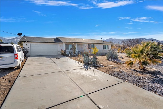 single story home with a garage and a mountain view