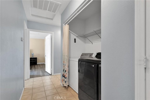 laundry area featuring light tile patterned flooring and washing machine and clothes dryer