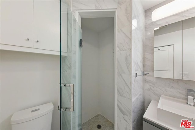 bathroom featuring toilet, vanity, tile walls, and an enclosed shower