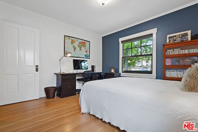 bedroom with light hardwood / wood-style floors and crown molding