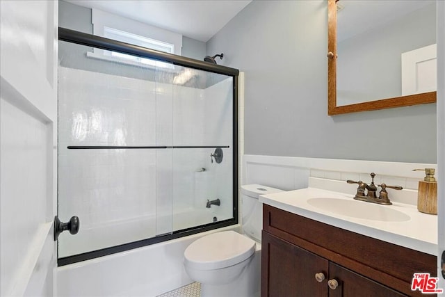 full bathroom with toilet, enclosed tub / shower combo, and vanity