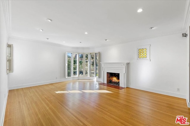 unfurnished living room featuring light wood-type flooring, a fireplace, crown molding, and basketball court