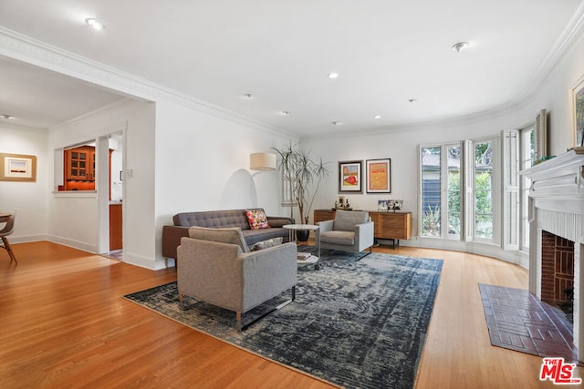 living room with a brick fireplace, light hardwood / wood-style flooring, and ornamental molding