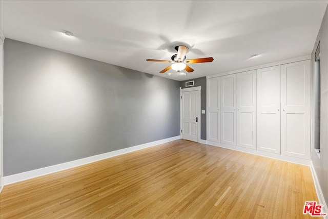 unfurnished bedroom featuring light wood-type flooring, ceiling fan, and a closet