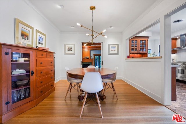 dining area featuring light hardwood / wood-style floors, crown molding, and a chandelier