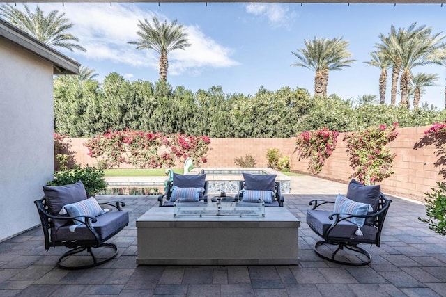 view of patio with an outdoor living space with a fire pit