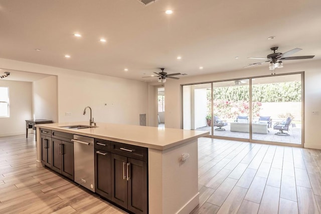 kitchen with dishwasher, sink, ceiling fan, a center island with sink, and dark brown cabinets