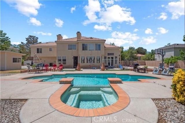 view of swimming pool with a patio area and an in ground hot tub