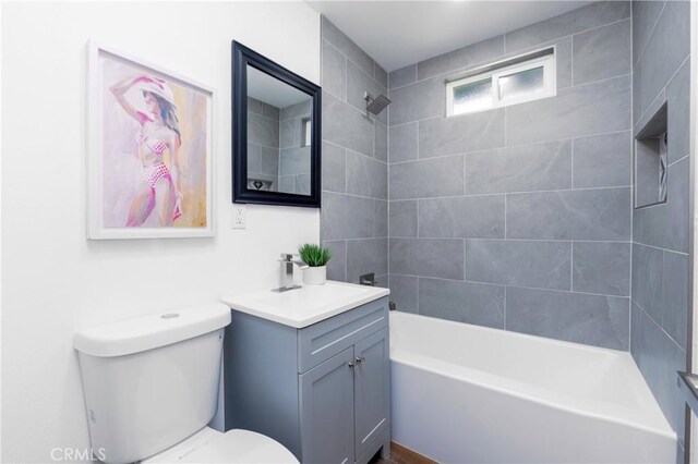 full bathroom featuring toilet, vanity, and tiled shower / bath combo