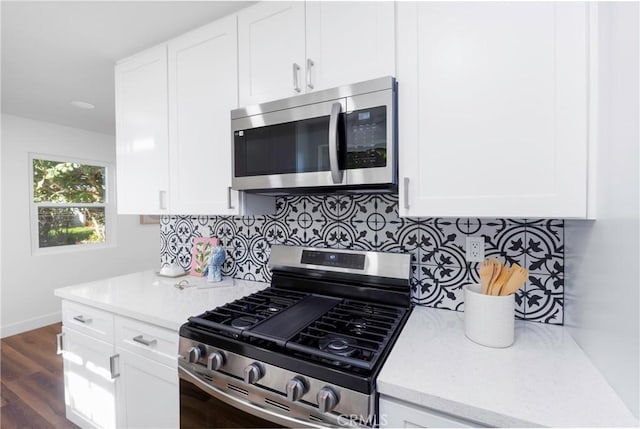 kitchen with stainless steel appliances, decorative backsplash, dark hardwood / wood-style flooring, and white cabinets