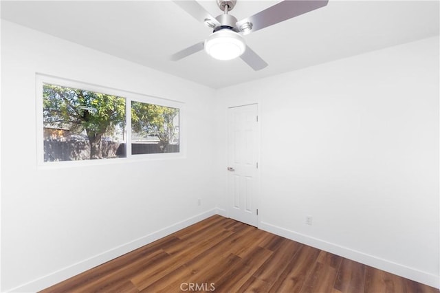 empty room with ceiling fan and dark hardwood / wood-style flooring