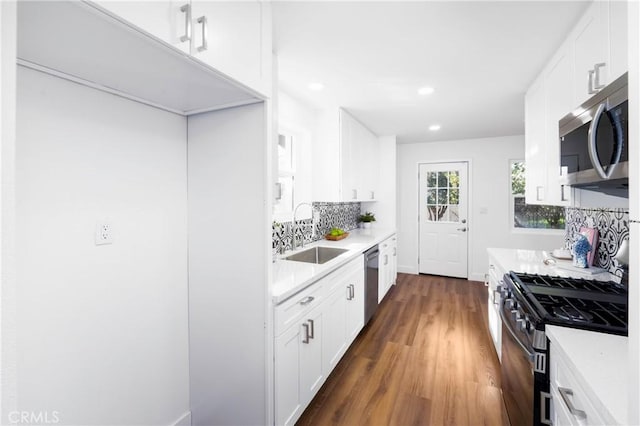 kitchen featuring dark wood-type flooring, sink, white cabinets, and appliances with stainless steel finishes