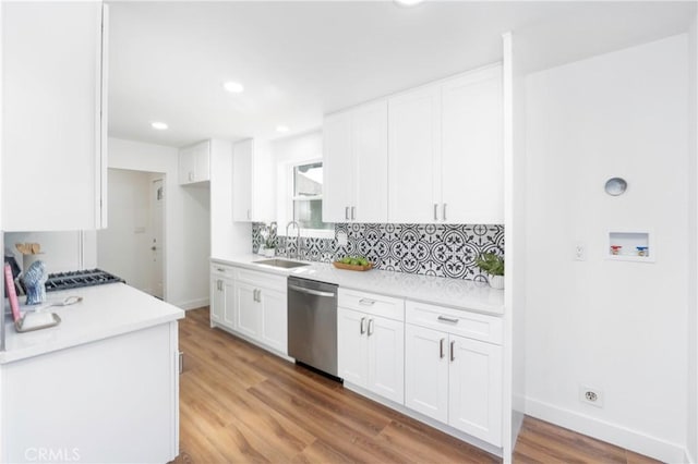 kitchen with white cabinetry, decorative backsplash, dishwasher, light hardwood / wood-style flooring, and sink