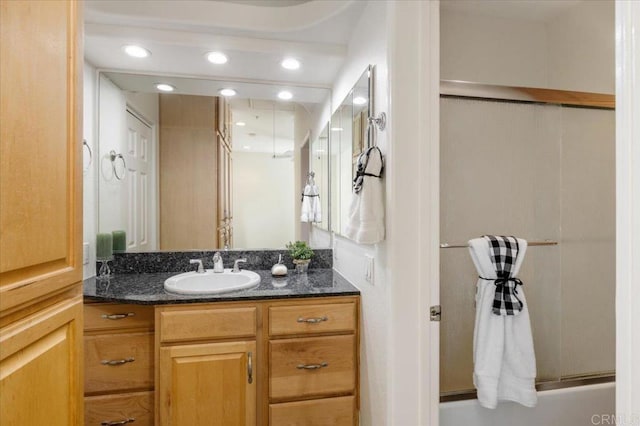 bathroom with vanity and enclosed tub / shower combo