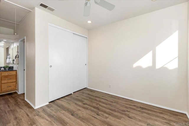 unfurnished bedroom featuring dark hardwood / wood-style flooring, a closet, and ceiling fan