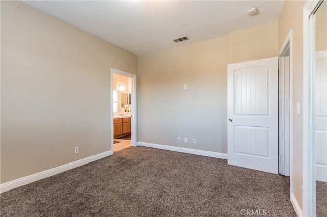 unfurnished bedroom featuring carpet flooring and connected bathroom