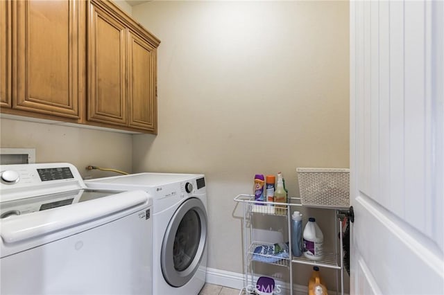 washroom with cabinets, separate washer and dryer, and light tile patterned floors