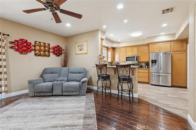 living room featuring hardwood / wood-style flooring and ceiling fan