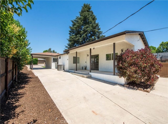 view of front facade with central AC unit and a carport