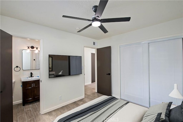 bedroom featuring ensuite bathroom, ceiling fan, hardwood / wood-style floors, sink, and a closet