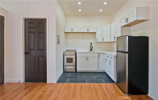 kitchen featuring dark wood-type flooring, sink, white cabinetry, and appliances with stainless steel finishes