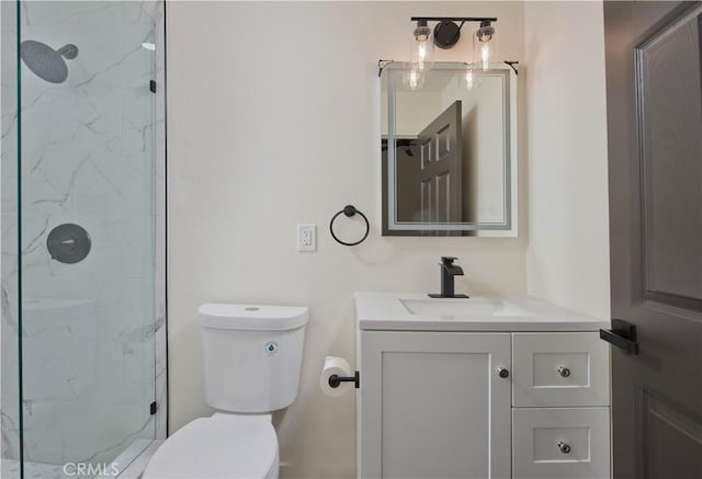 bathroom featuring toilet, vanity, and a tile shower