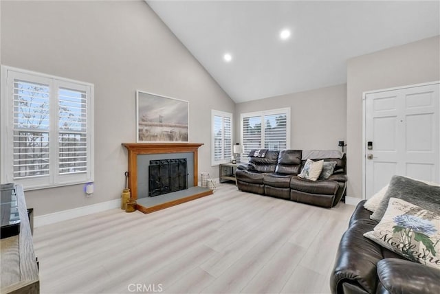 living room with light hardwood / wood-style flooring and high vaulted ceiling