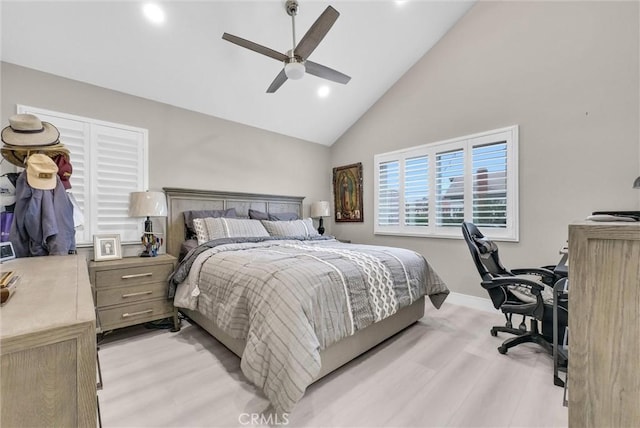 bedroom with ceiling fan, light hardwood / wood-style floors, and high vaulted ceiling