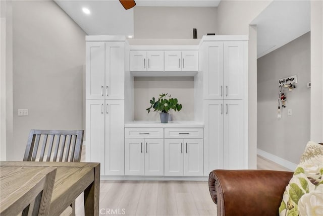 dining space with ceiling fan and light wood-type flooring