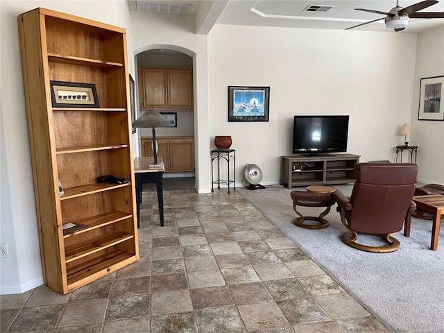 living room featuring built in shelves and ceiling fan