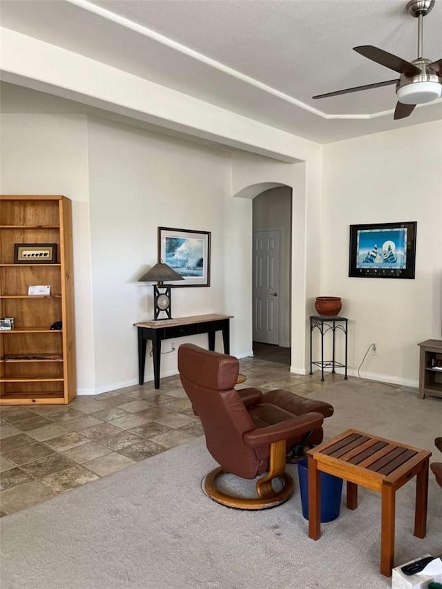 carpeted living room with ceiling fan