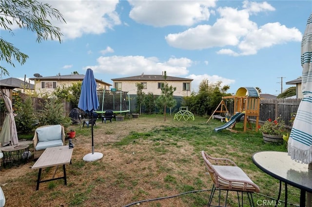 view of yard with a trampoline and a playground