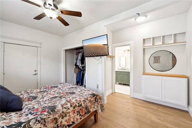 bedroom featuring ceiling fan, sink, light hardwood / wood-style flooring, and ensuite bath