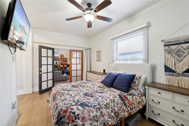 bedroom featuring ceiling fan, light hardwood / wood-style flooring, and french doors