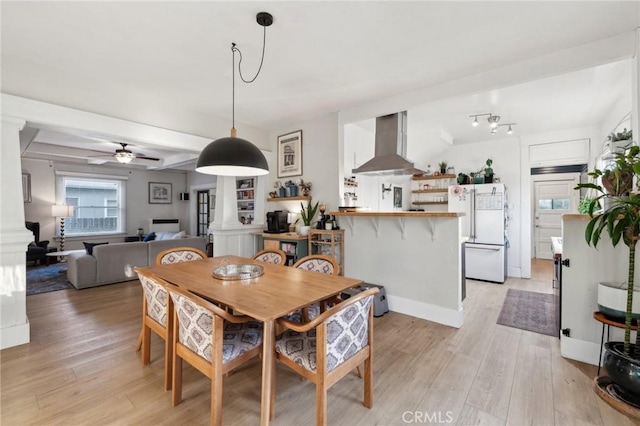 dining area with light wood-type flooring and ceiling fan