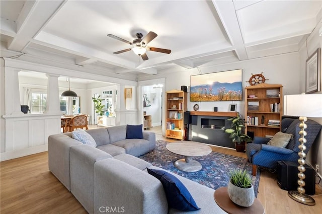 living room featuring ceiling fan, beamed ceiling, and light hardwood / wood-style floors