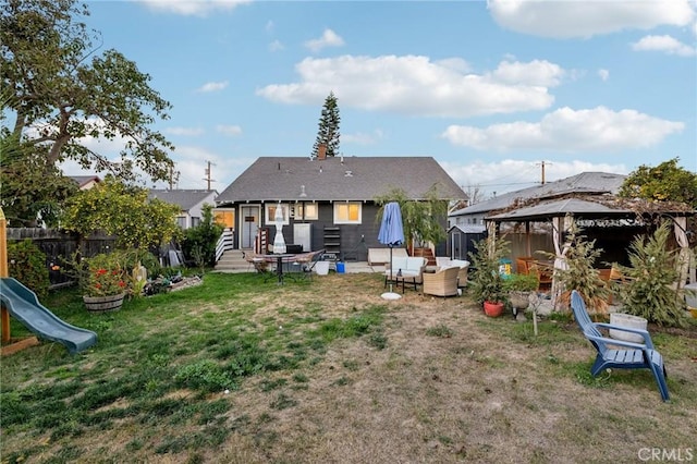 rear view of house featuring a gazebo and a yard