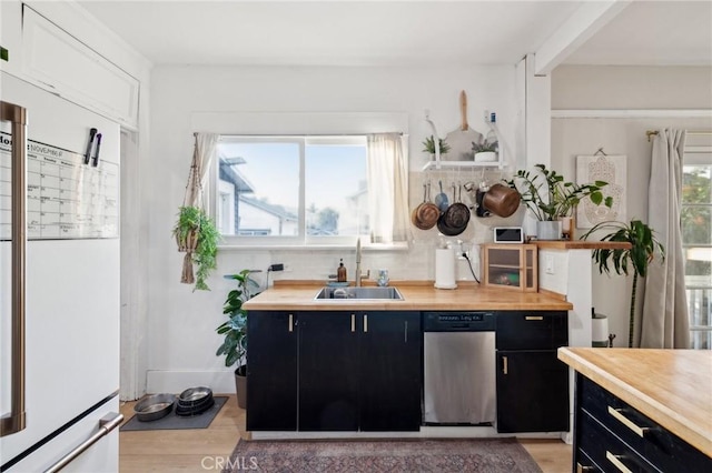 kitchen featuring dishwasher, wooden counters, white fridge, light hardwood / wood-style floors, and sink