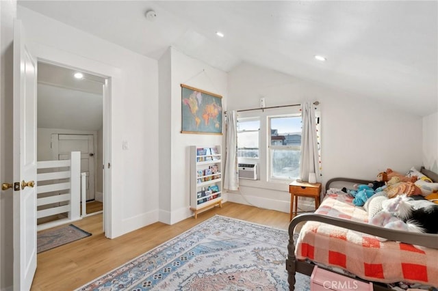 bedroom featuring wood-type flooring, lofted ceiling, and cooling unit