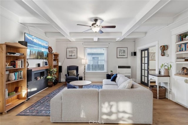 living room featuring ceiling fan, light hardwood / wood-style floors, beam ceiling, and coffered ceiling