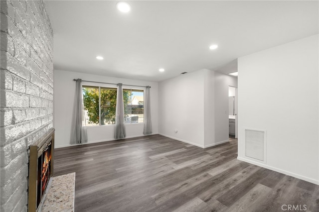 unfurnished living room with a fireplace, recessed lighting, visible vents, wood finished floors, and baseboards