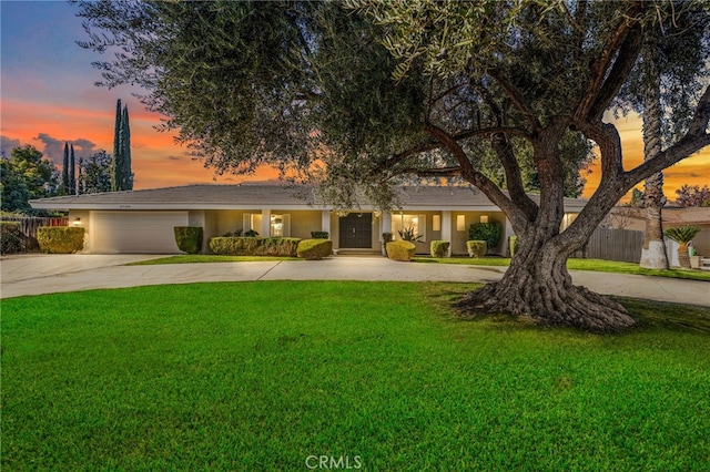 view of front of house with driveway, fence, an attached garage, and a lawn