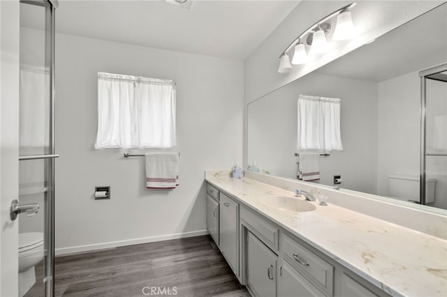 full bath with wood finished floors, vanity, toilet, and baseboards